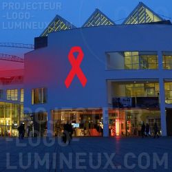 Proiezione di nastro luminoso rosso all'aperto sugli edifici per la sensibilizzazione sull'AIDS