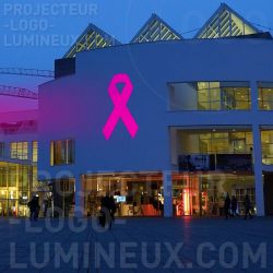 Proiezione di nastri luminosi rosa sulla facciata dell'edificio per la sensibilizzazione sul cancro